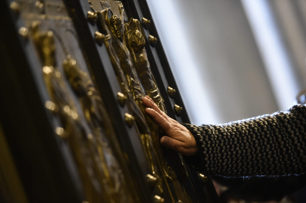 Passaggio dei pellegrini attraverso la porta Santa della basilica di San Pietro